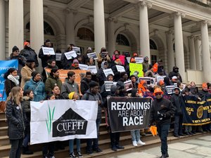 50 people congregate on the steps of City Hall with signs reading "Rezonings are about Race"