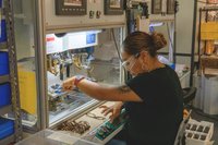 Employee crafting reading glasses at a production machine. 