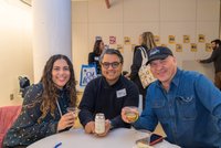 Group of three cheers to the photographer at a networking event. 