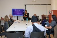 Someone one presenting to people at a table.