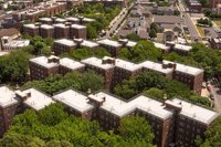 Aerial photograph showing three adjacent public housing buildings that form a zig zag pattern with trees growing between them