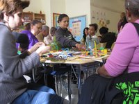 A group of adults and children use found objects to share ideas for improving their neighborhood