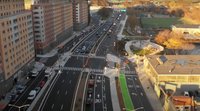 Aerial image of a 6-lane street with newly installed crosswalks, which connect several mid-rise housing developments on one side of the street with the parks and sports fields on the opposite side.