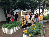 Students holding colorful fabrics in the Textile Dye Garden on the Pratt Brooklyn campus. 