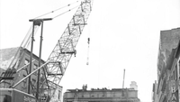 Cross-section of a viaduct being disassembled by a crane